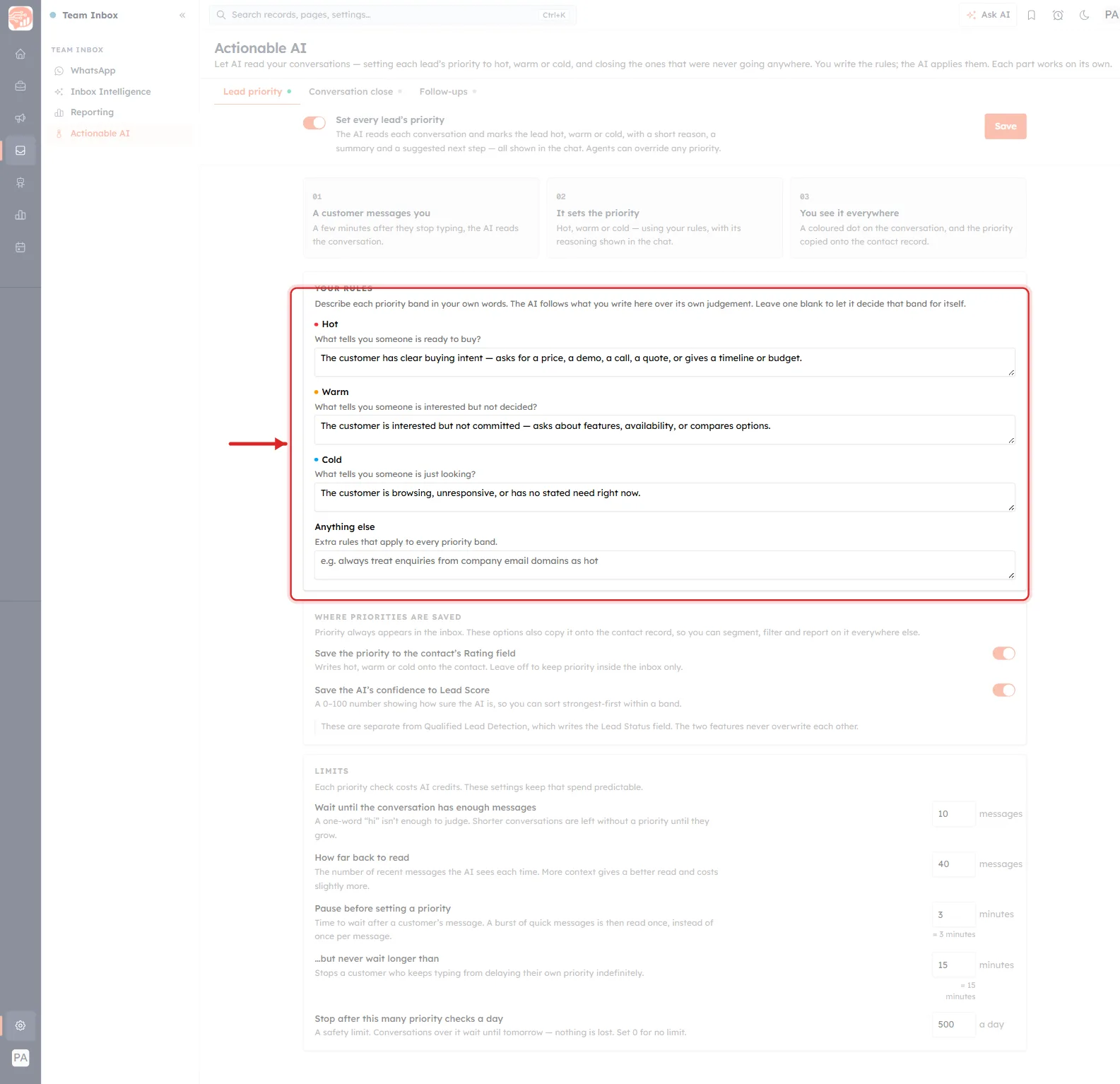 The whole Team Inbox Actionable AI page in a single full-height view, with everything dimmed except one card. A red rounded rectangle rings the YOUR RULES card in the middle of the page and a red arrow points at it from the left. Down the left edge is the dark navy icon rail, then the white Team Inbox menu listing WhatsApp, Inbox Intelligence, Reporting and Actionable AI, with Actionable AI highlighted in orange. The main column reads, from the top: the heading Actionable AI above the line Let AI read your conversations — setting each lead’s priority to hot, warm or cold, and closing the ones that were never going anywhere. You write the rules; the AI applies them. Each part works on its own. Below it a row of three tabs — Lead priority, underlined in orange with a green dot, then Conversation close and Follow-ups, each with a grey dot. Then an orange toggle switched on beside the bold label Set every lead’s priority, with an orange Save button at the far right. Then three numbered cards reading 01 A customer messages you, 02 It sets the priority and 03 You see it everywhere. Then the ringed YOUR RULES card, holding four labelled boxes for Hot, Warm, Cold and Anything else. Below the ring, a WHERE PRIORITIES ARE SAVED card with two toggles switched on, and a LIMITS card with five numeric settings reading 10 messages, 40 messages, 3 minutes, 15 minutes and 500 a day.